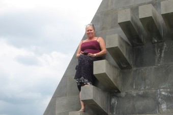 Bild: Susi auf Monument in weiter Landschaft